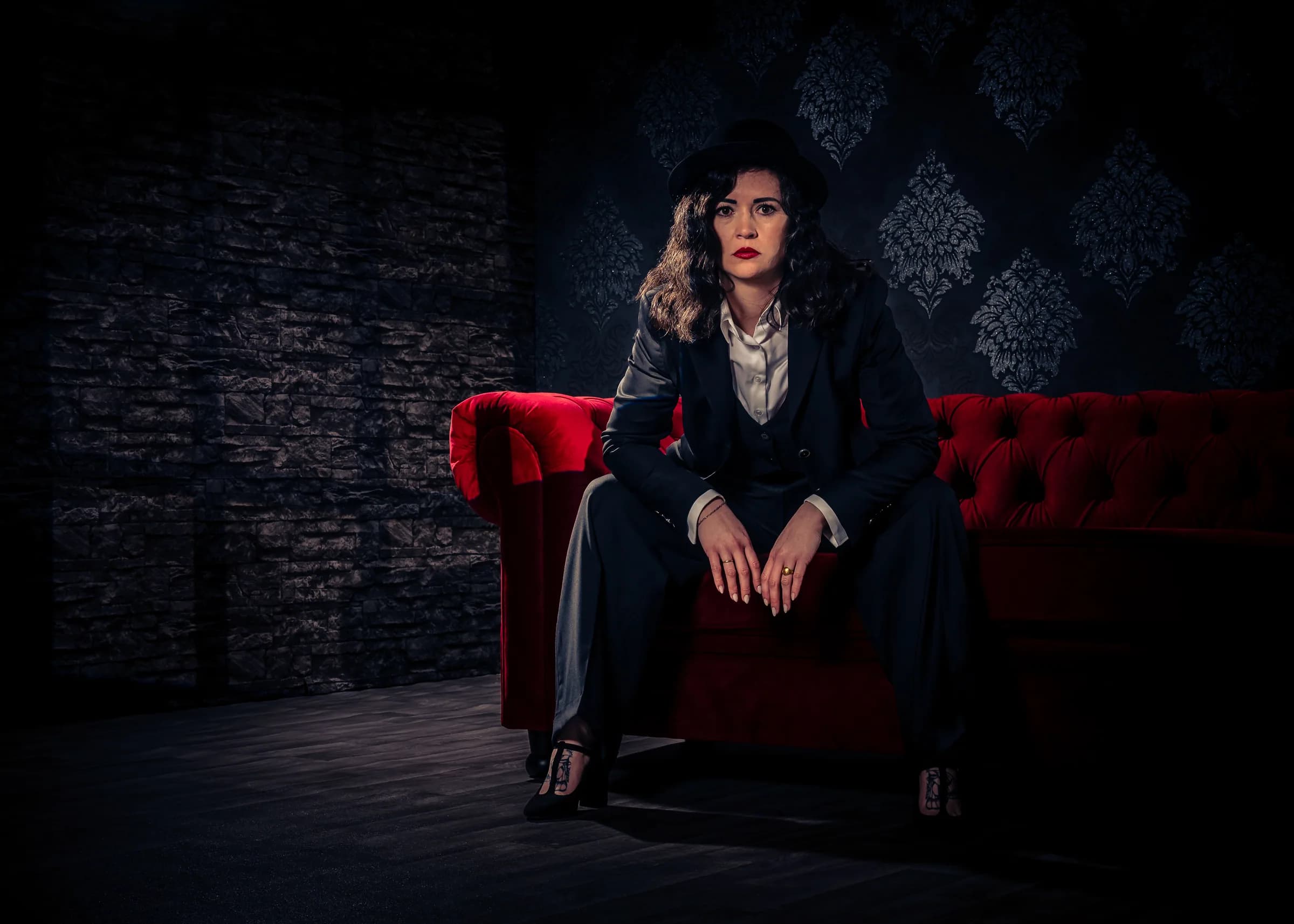 Frau im Nadelstreifenanzug auf rotem Sofa, Studio